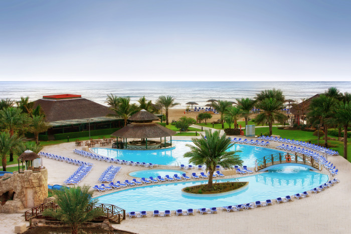Unforgettable experience at Fujairah Rotana Resort & Spa with lush gardens, white sand beaches, and cascading waterfalls